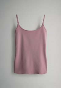 Světle růžový top na tenké ramínka, vyrobený z měkké tkaniny. Jednoduchý design, rovný lem a hladká textura bez vzorů nebo zdobení.