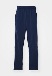 Marinblå sportbyxor med elastisk midjeresår, med sidopaneler i ljusblå och en liten logodetalj nära fållen. Slät textur.