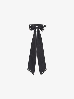 Gravata de tecido preto com um topo em forma de laço, apresentando rebites prateados nas laterais e extremidades pontiagudas. Textura suave, design clássico.
