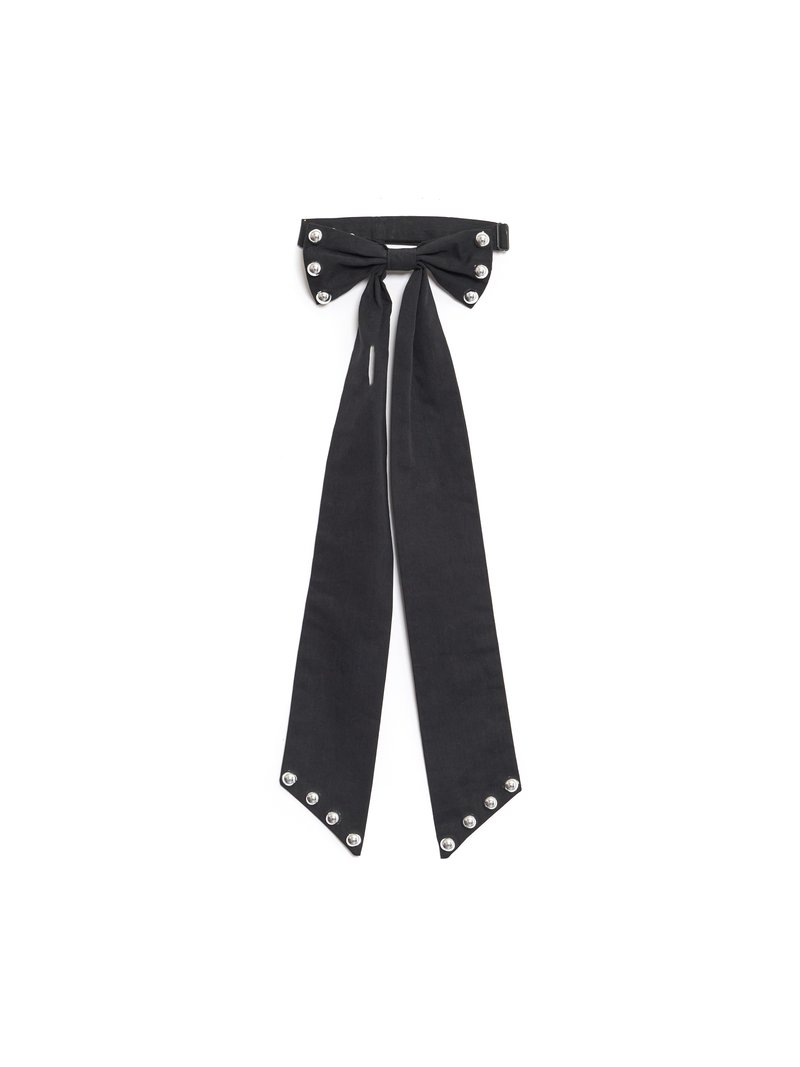 Svart stoff slips med bueformet topp, prydet med sølvnagler på sidene og spisse ender. Glatt tekstur, klassisk design.