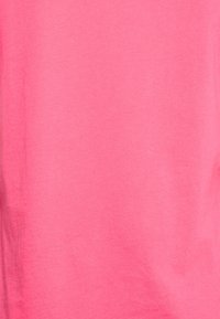 T-shirt à manches courtes en coton doux, de couleur rose vif unie, avec une texture lisse sans motifs ni accents visibles.