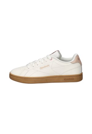 Witte Reebok lage sneaker met gumrubberen zool, witte veters en roze accenten op de hiel en het logo aan de zijkant en onder de zool.