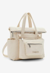 Beige nylon handbag with dual top handles, zippered main compartment, and detachable front pocket featuring a logo and silver hardware accents.