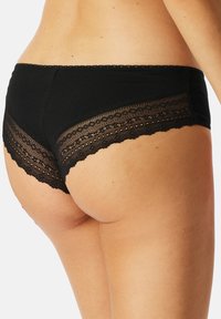 Zwarte katoenen slipjes met gekartelde kantafwerking en details, met een laag uitgesneden ontwerp. Soepele textuur met een elastische tailleband.