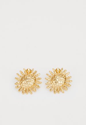 Goldene, sonnenförmige Ohrringe mit strukturiertem Oberflächen und strahlenden Strahlen. Sie verfügen über ein zentrales, kreisförmiges Design und ausgeprägte Sunmuster-Details.