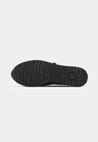 Black shoe sole featuring a textured, ridged pattern for traction, marked with size and brand logo. Durable rubber construction.