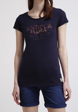 Camiseta de algodón azul marino de manga corta, con escote redondo y texto en relieve que dice "Antigua Classic Yacht Week" en colores metálicos.
