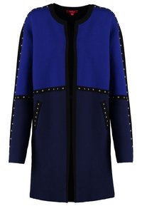 Blau-schwarze Strickjacke aus weichem Material, mit silbernen Nieten entlang der Nähte und zwei seitlichen Taschen. Offenes Frontdesign mit langen Ärmeln.