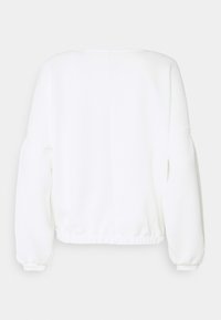 Bílý pulovr se strukturovaným povrchem, kulatým výstřihem a elastickými manžetami. Má krátký střih s nařaseným pasem.