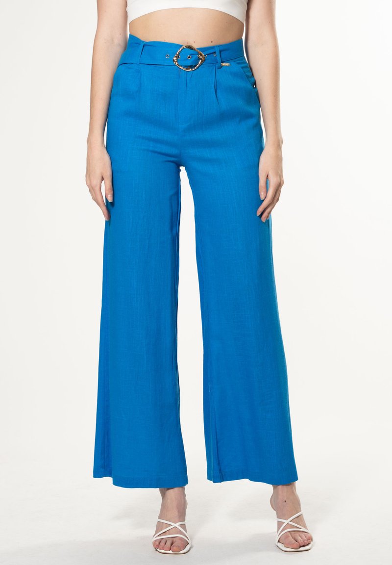 Heldere blauwe wijde broeken van een textuurstof, met een gouden ronde gesp riem en voorzakken.