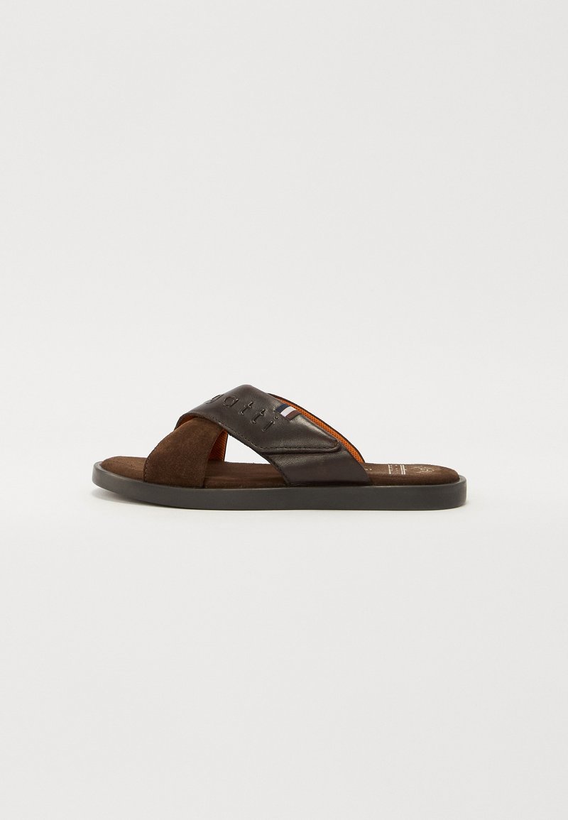 Brune sklisandal med kryssremdesign i matt lær og semsket skinn. Teksturert innersåle, flat gummisåle og subtil merkevaredetalj.