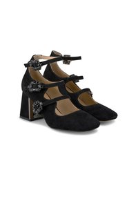 Zapatos de tacón alto de ante negro con punta cuadrada, múltiples correas en el tobillo y acentos de hardware decorativo en los costados. Diseño de tacón grueso.