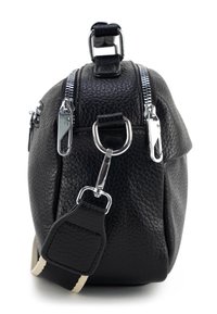 Zwarte leren tas met een textuurafwerking, voorzien van zilveren hardware, twee ritsen, een D-ring en een stoffen schouderband met crèmekleurige strepen.