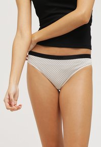 Bijele gaćice s crnim pojasom i "DIM" logom. Izrađene od mekog materijala, s klasičnim bikini krojem.