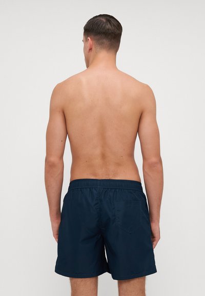 Shorts de baie bleumarin cu talie elastică, buzunar pe spate și textură netedă, afișați din spate fără caracteristici suplimentare.