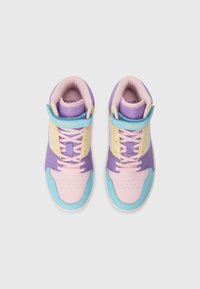 Pastelroosa, lilla, kollane ja sinise paneelidega kõrged sneakersid roosa paeltega, vaadatuna ülalt valgel taustal.