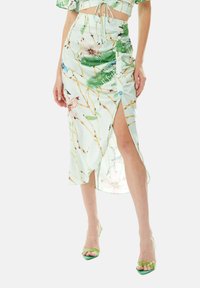 Floral-patterned, light green midi skirt with a side slit, adjustable waist tie, and button details. Smooth fabric with a soft texture.