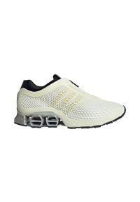 Ελαφριά κρέμα αθλητικά παπούτσια με άνω μέρος από πλέγμα, μαύρες λεπτομέρειες και καουτσούκ σόλα που διαθέτει ορατά στοιχεία αερόφυσης και υφή σχεδίασης.