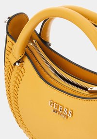 Borsa a tracolla in pelle gialla con dettagli intrecciati, doppi manici superiori e chiusura con zip. Presenta elementi in metallo e logo stampato.