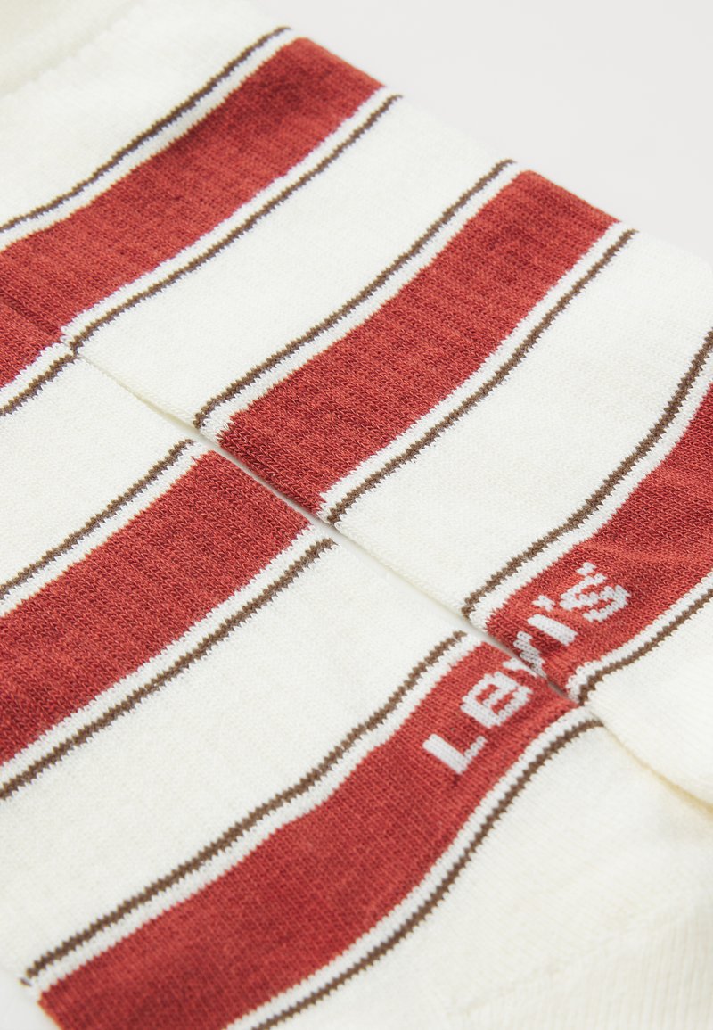 Gestreepte sokken met een crèmekleurige basis en rode en bruine strepen, van gebreid materiaal, met het "Levi's" logo in het wit aan de zijkant.