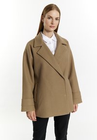 Beige wollen blend jas met een opstaande kraag, brede revers en dubbele knopen aan de voorkant. Beschikt over zijzakken en manchetten met omslag.