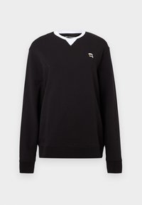Sort sweatshirt med lange ærmer, V-hals, hvid krave og lille broderet logo på brystet. Blødt stof med en glat overflade.