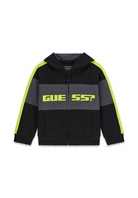 Schwarze und graue Zip-Up Kapuzenjacke mit neon-gelben Streifen an den Ärmeln und dem Text "GUESS?" auf der Brust.