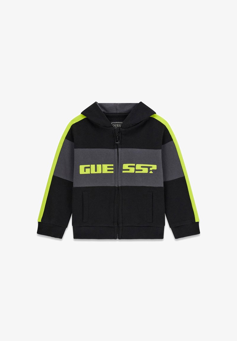 Schwarze und graue Zip-Up Kapuzenjacke mit neon-gelben Streifen an den Ärmeln und dem Text "GUESS?" auf der Brust.