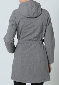 Manteau long gris avec capuche, en tissu texturé, taille ceinturée et détails de coutures. Pas de ferrures visibles ni de motifs.