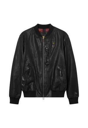Blouson aviateur en cuir noir avec fermeture éclair frontale, col et poignets côtelés, trois poches zippées et un petit patch sur la manche gauche.