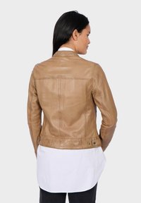 Veste en cuir marron au design ajusté, dotée d'une fermeture à boutons-pression et d'une texture lisse légèrement brillante. La vue arrière montre les détails des coutures.