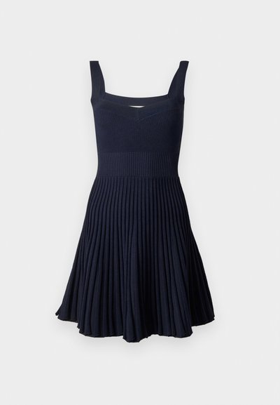 Marineblauw geplooid jurkje met een aansluitende lijfje, brede schouderbanden en een uitlopende rok. Gemaakt van ribbelstof met een licht gestructureerd oppervlak.