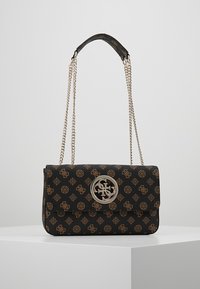 Sac à main noir avec une finition en cuir texturé, des bretelles en chaîne dorée pour l'épaule, et une fermeture logo circulaire avec un motif dessiné.