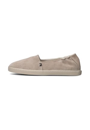 Beige suede instap schoenen met een laag profiel, ronde neus en contrasterende stiksel details langs de zool. Weinig merkvermelding zichtbaar.