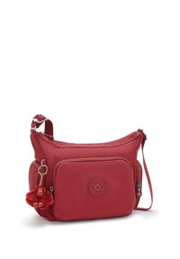 Rød nylon crossbody taske med en tekstureret overflade, lynlåslommer, rundt logo-patch og en abe-nøglering som pynt. Justerbar rem.