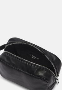 Neceser de cuero negro con un cierre plateado, bordes redondeados y una textura suave. El interior muestra el nombre de la marca "LIEBESKIND BERLIN."