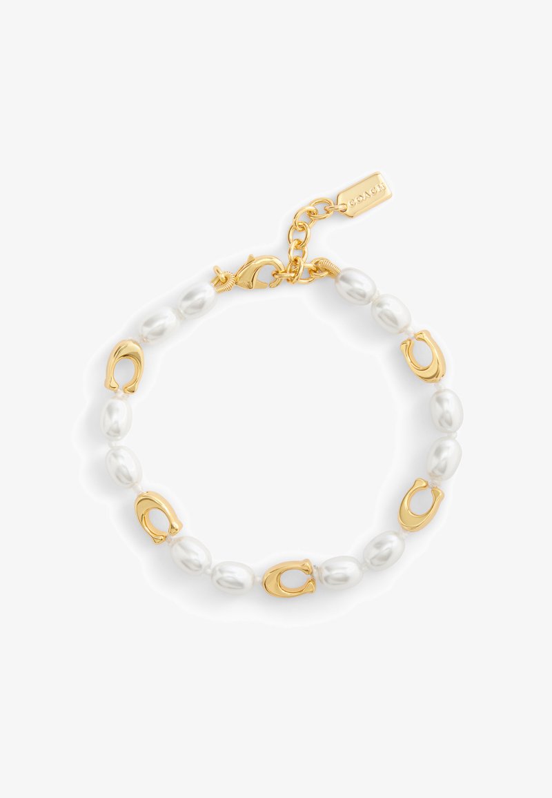 Bracelet doré avec des perles ovales et des accents en forme de fer à cheval. Comprend un fermoir avec une chaîne et une étiquette de marque.