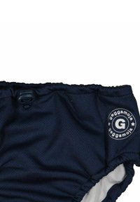 Tummansiniset uimapohjamaat, jotka on valmistettu verkkokankaasta, kerrottu sivuineen. Niissä on nepparikiinnitys ja logopatch, jossa on kirjain "G".