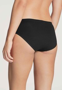 Black cotton brief with a high waist and seamless design. Features subtle stitching and a smooth texture for comfort.
