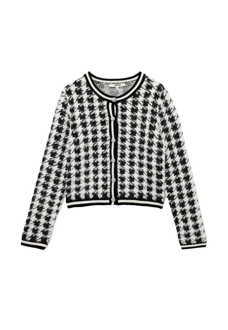 Svart och vit mönstrad cardigan med en houndstooth-design, kort längd, rund halsringning och svarta detaljer med knäppning.