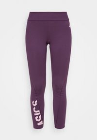 Leggings atléticos morados con cintura alta, que presentan un estampado de logo rosa en la pierna izquierda y una textura de tejido suave y elástico.