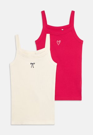 Twee mouwloze tanktops met dunne bandjes, één witte met een klein strikje, één roze met een klein hartje, plat neergelegd op een witte achtergrond.