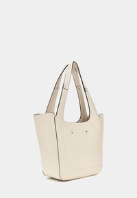 Beige leren totebag met dubbele handvatten, zachte textuur, gestructureerde vorm en contrasterende zwarte stiksels langs de randen. Voorkant met minimalistische details.