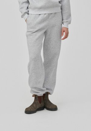 Hallide hallid puuvillased dressipüksid elastse vöökoha, küljetaskute ja kitseneva säärekujundusega. Kombineeritud pruunide pahkluu saapadega, millel on elastsed küljed.