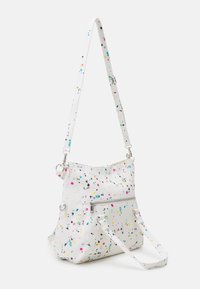 Biała torba na ramię z kolorowym wzorem w plamy, tekstura materiału, regulowany pasek, przednia kieszeń na zamek i srebrne akcenty metalowe.