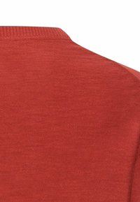 Zbliżenie na czerwoną dzianinę pokazującą górną część pleców i obszar ramienia ubrania z prążkowanym dekoltem.