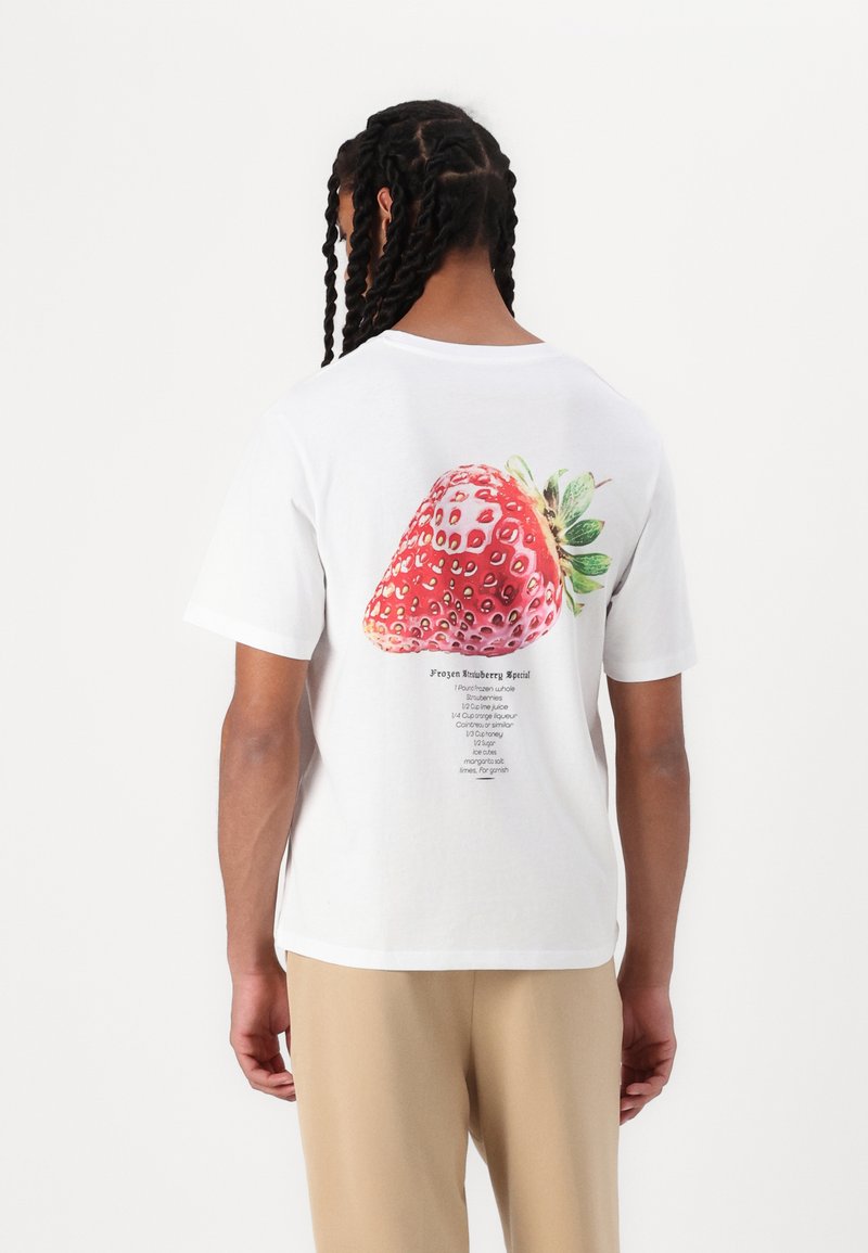 Camiseta de algodón blanca con un gran gráfico de fresa detallado en la parte posterior, junto con el texto de la receta debajo en fuente negra.