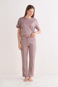 Krátký rukáv, zkrácený top v barvě mauve s kapsou; odpovídající mauve lehké kalhoty s pružným pasem a bočními kapsami. Hladká textura.