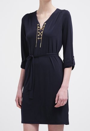 Navyblaues Kleid mit V-Ausschnitt, 3/4-Ärmeln, goldener Kettendetail und einem Bundgürtel. Glattes Material mit lockerer Passform.