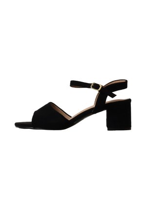 Black suede open-toe sandal with block heel and ankle strap secured by a gold buckle, viewed from the side on a white background.